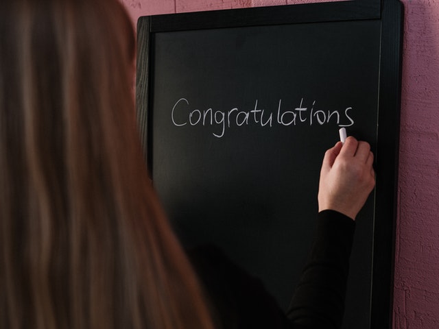 women writing on blackboard congratulations